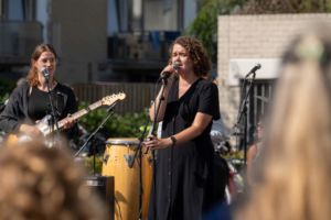 Vrouw aan het zingen met gitaarmuziek. Optreden van een band.